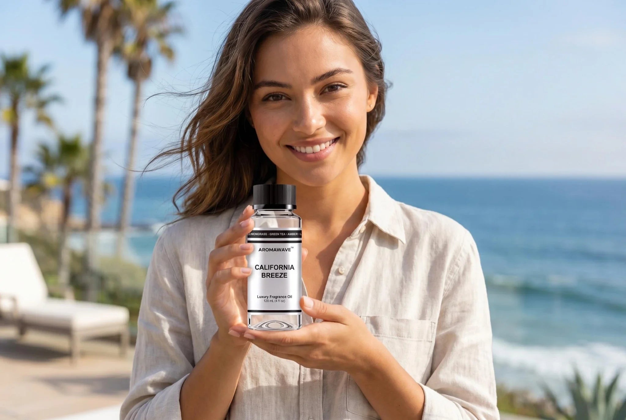 Luxury home fragrance oil bottle held by smiling woman by the ocean, Aromawave California Breeze fragrance oil for premium home scenting and diffuser use in Australia